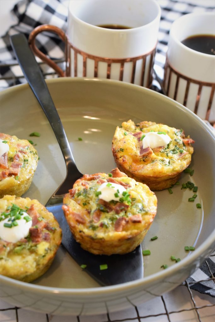 tater tot brunch bites in grey round ceramic casserole with black pie server 