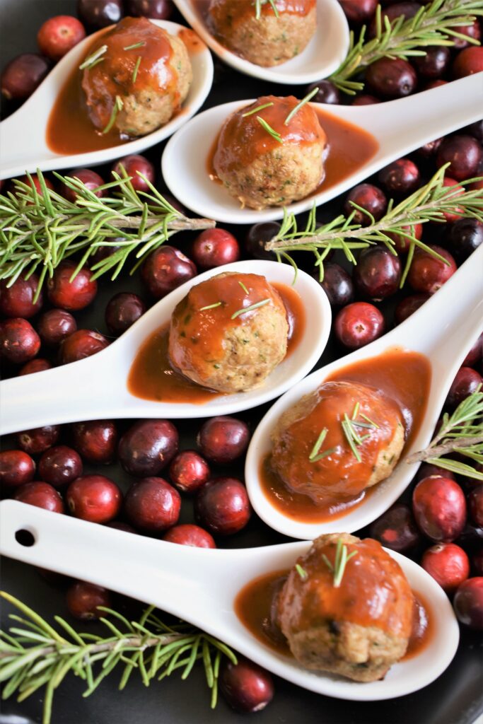 festive holiday meatballs in white spoons with cranberries 