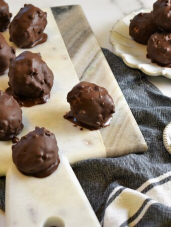 gray and white marble handled board with several peanut butter s'more bombs displayed on it with traditional ones off to the side on dishes