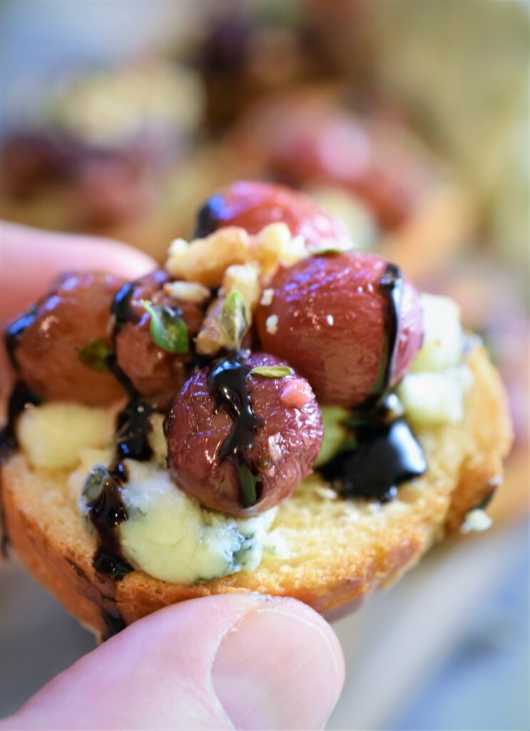 holding a single piece of bruschetta