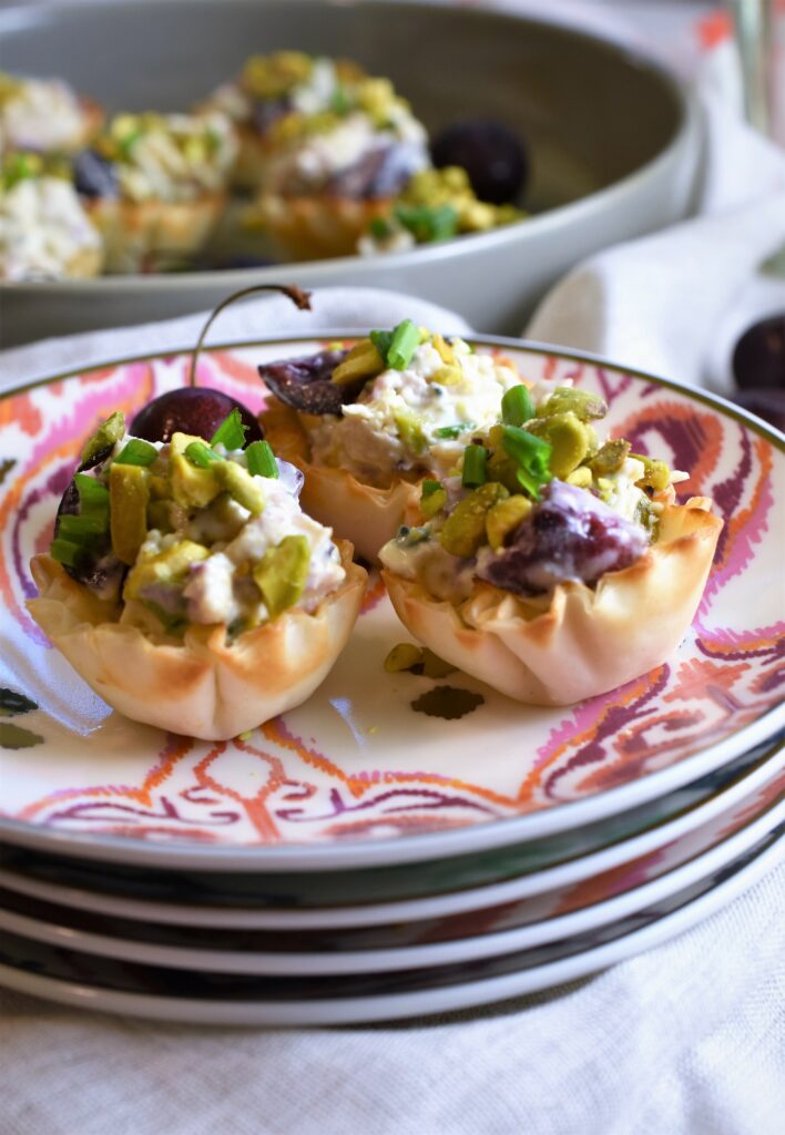 stack of appetizer plates with top dish of phyllo cup appetizer