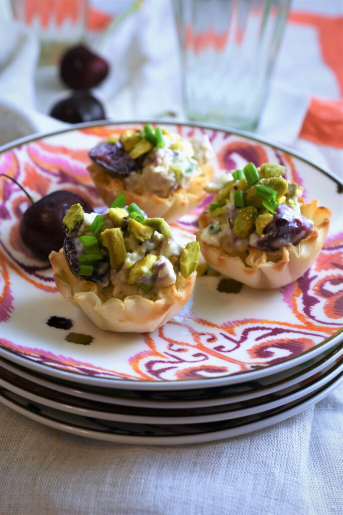 up close view of 3 chicken salad phyllo tarts with fresh cherries 