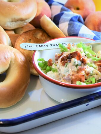 white and red bowl with bagel spread with numerous bagels on a tray