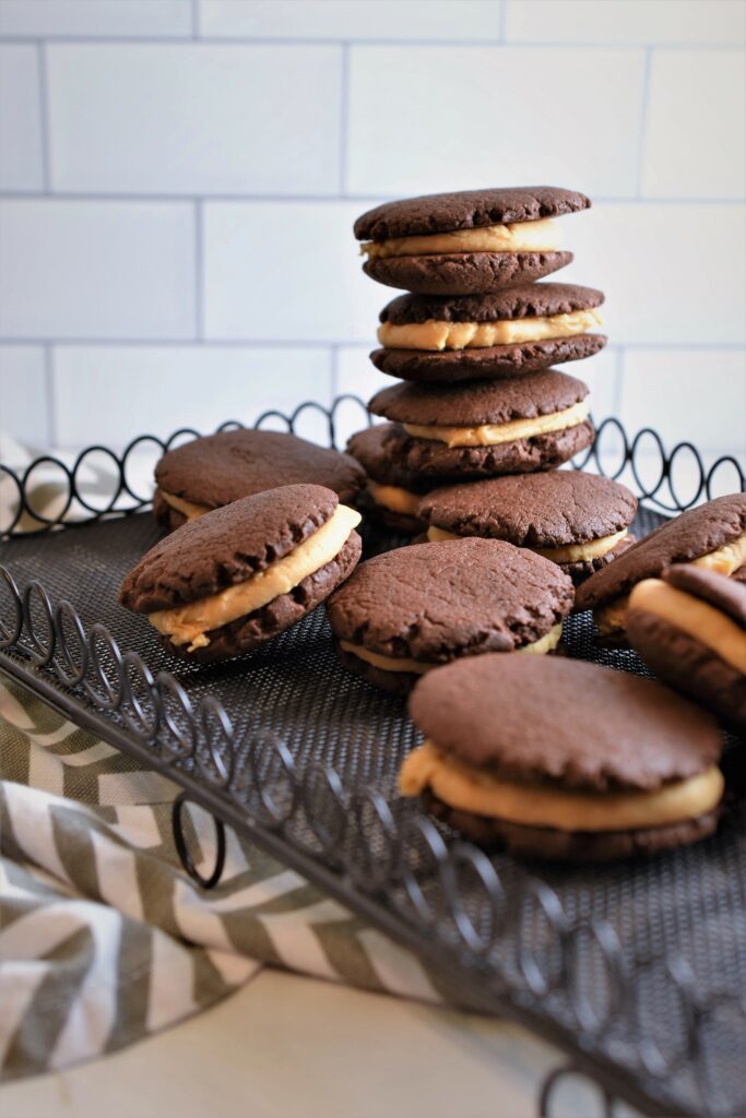 sandwich cookies stacked on cooling rack with some laying flat