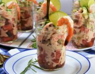 chilled shrimp appetizer in jar on blue and white plate with gold fork