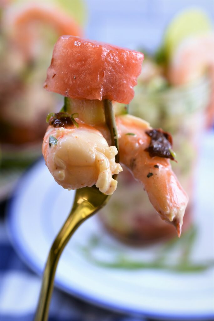 single cocktail fork view of watermelon cube, cucumber and shrimpl