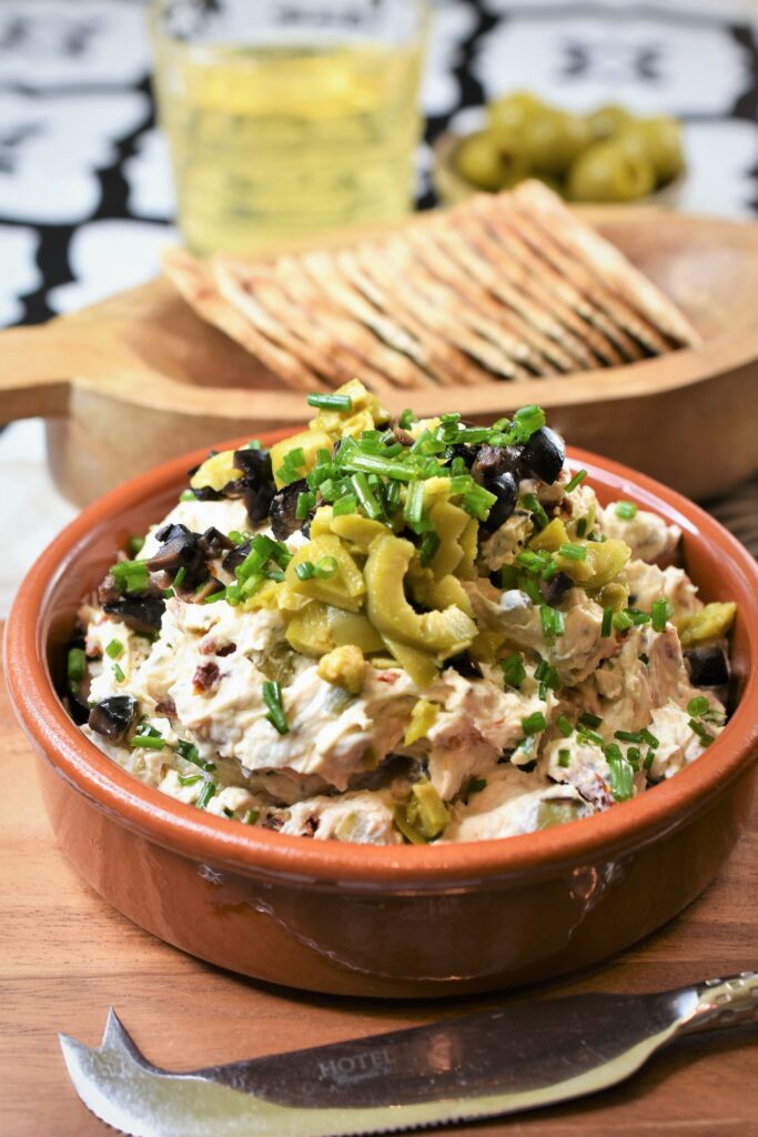 appetizer spread in Mediterranean tapas dish on cutting board with crackers