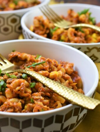 vegan chorizo Mexican goulash in 3 modern gold and white bowls with gold forks