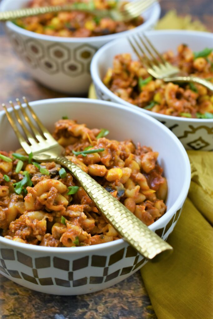 vegan macaroni casserole in modern gold and white bowls