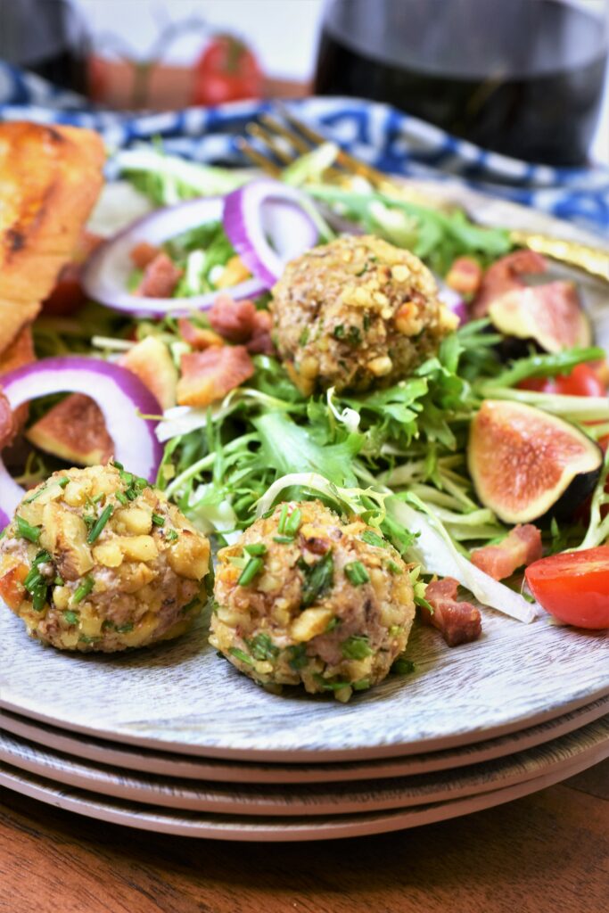 mini nut and cheese balls on frisee salad with crispy pancetta