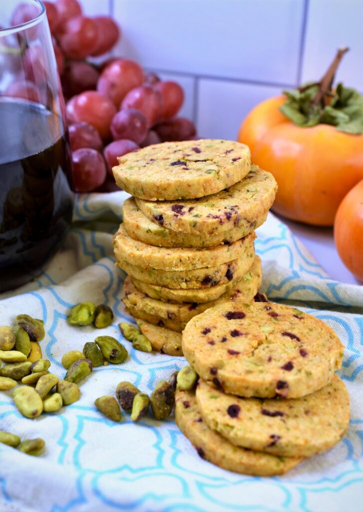 cranberry pistachio shortbread crackers stacked high with a glass of red wine