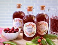 cranberry serrano chile with orange in several corked glass bottles on cutting board