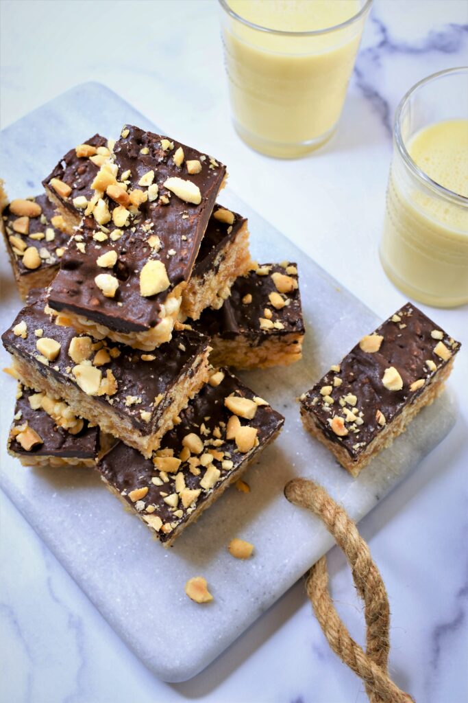 cereal bars with chopped peanuts on top of white marble cutting board