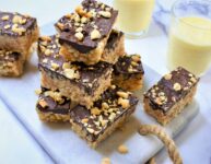 rice crispy treats with dark chocolate and peanut butter on white marble countertop