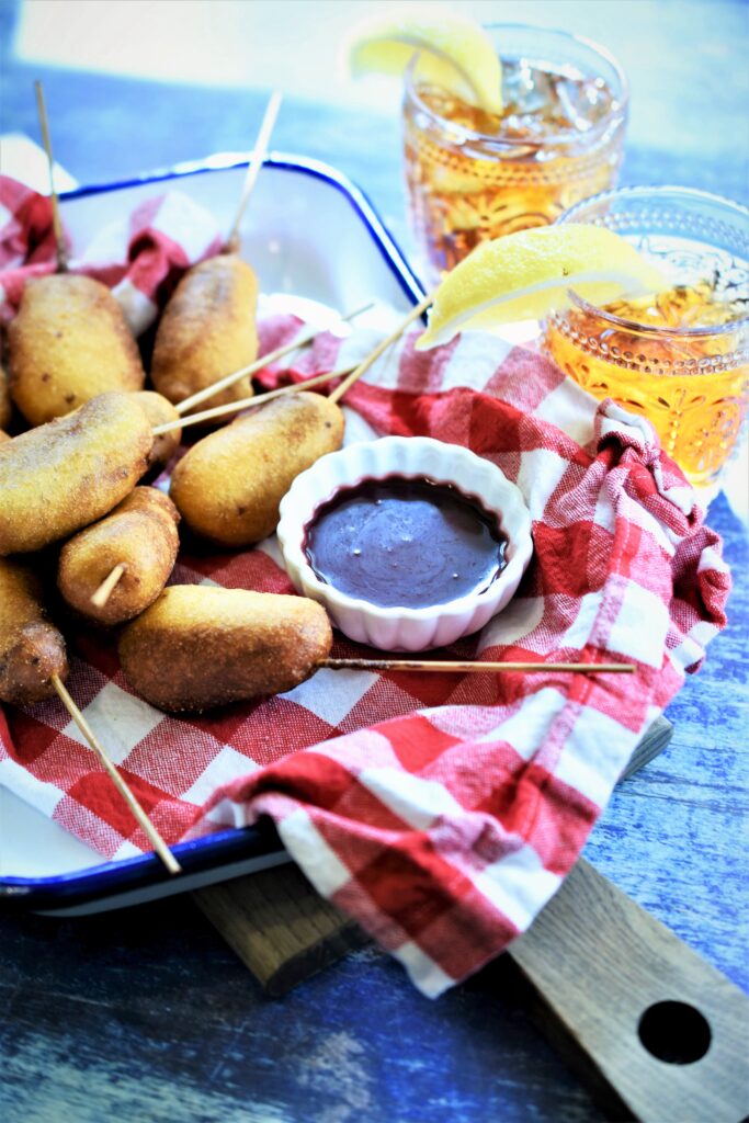 mini chipotle dogs on a stick with blackberry sauce