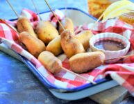 Mini Chipotle Corn Dogs with Blackberry Honey Mustard ready for the Super Bowl on blue and white metal tray with red and white checker napkin