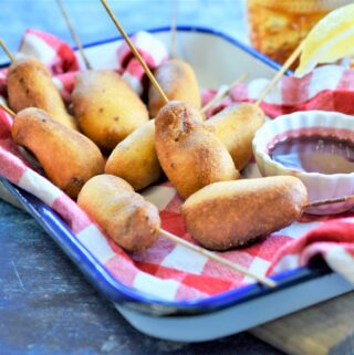 Mini Chipotle Corn Dogs with Blackberry Honey Mustard ready for the Super Bowl on blue and white metal tray with red and white checker napkin
