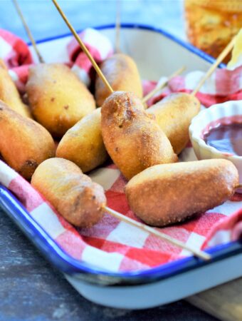 Mini Chipotle Corn Dogs with Blackberry Honey Mustard ready for the Super Bowl on blue and white metal tray with red and white checker napkin